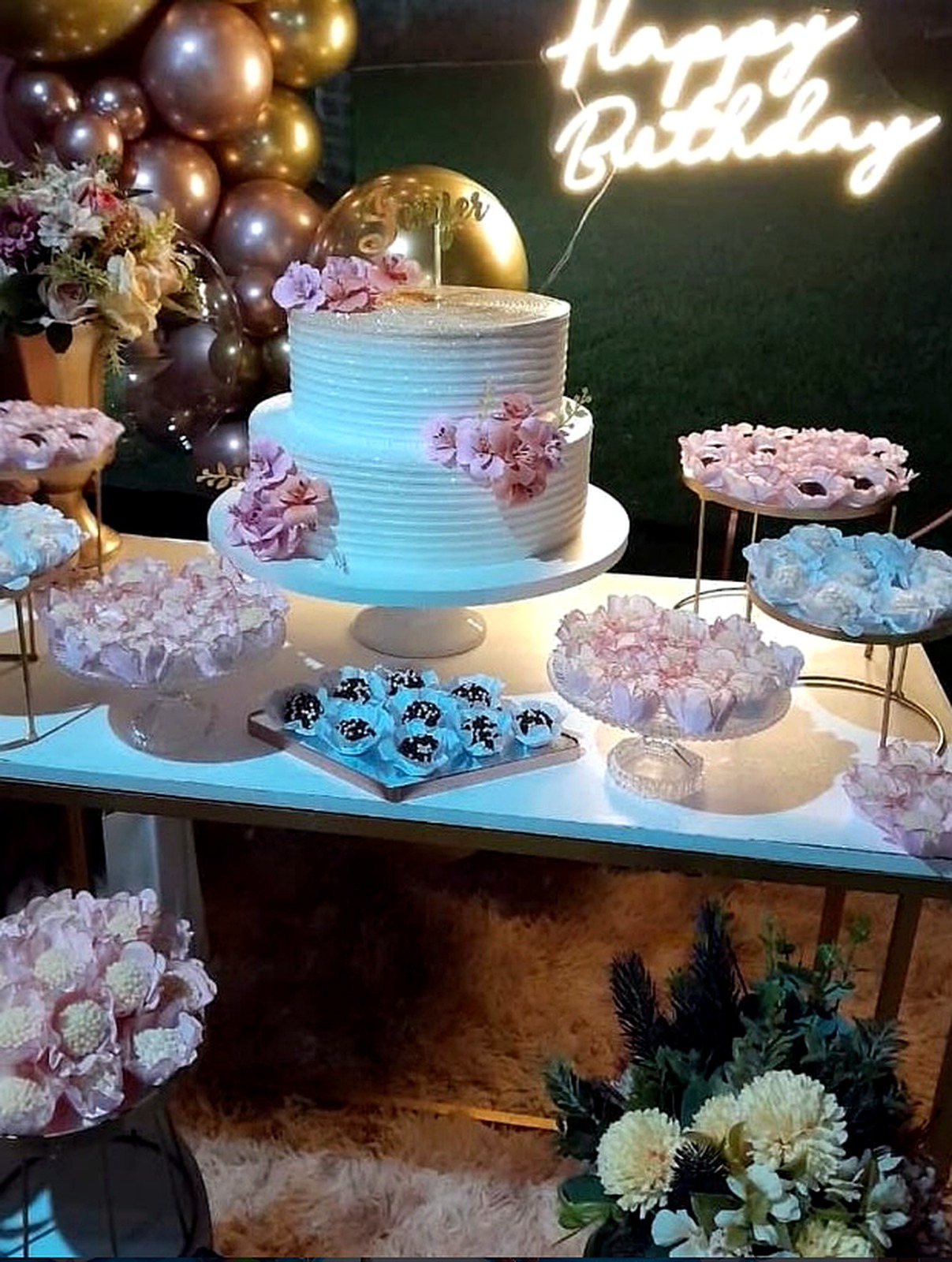 Mesa decorada com bolo e doces Júlia Bolos